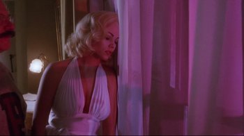 Movie still from “Insignificance” (1985), directed by Nicolas Roeg – A woman in a white dress standing in front of a window; Medium shot, Low angle