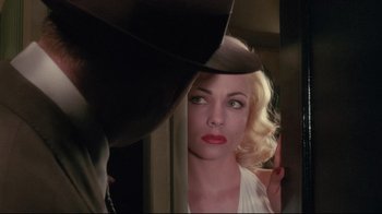 Movie still from “Insignificance” (1985), directed by Nicolas Roeg – A woman looking into a mirror while wearing a hat; Close Up shot, Over the shoulder angle