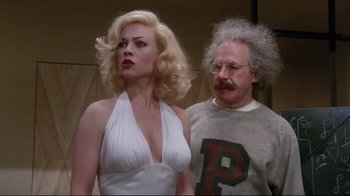 Movie still from “Insignificance” (1985), directed by Nicolas Roeg – A man and a woman standing next to each other; Medium shot, Over the shoulder angle