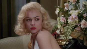 Movie still from “Insignificance” (1985), directed by Nicolas Roeg – A woman with blonde curly hair sitting in front of a mirror; Close Up shot, Over the shoulder angle