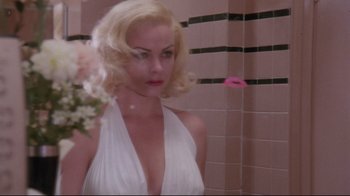 Movie still from “Insignificance” (1985), directed by Nicolas Roeg – A woman in a white dress holding a pink flower; Close Up shot, Over the shoulder angle