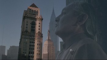 Movie still from “Insignificance” (1985), directed by Nicolas Roeg – An older woman looking out over a city skyline; Close Up shot, Low angle