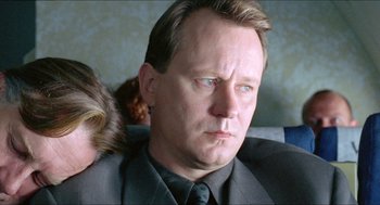 Movie still from “Insomnia” (1997), directed by Erik Skjoldbjærg – A person wearing a suit and tie; Close Up shot, Low angle