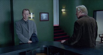 Movie still from “Insomnia” (1997), directed by Erik Skjoldbjærg – Two people sitting at a table in a room; Medium shot, Over the shoulder angle