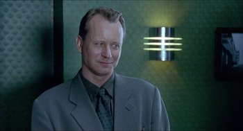 Movie still from “Insomnia” (1997), directed by Erik Skjoldbjærg – A person wearing a suit and tie; Close Up shot, Low angle
