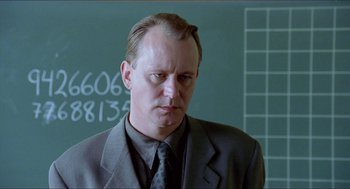 Movie still from “Insomnia” (1997), directed by Erik Skjoldbjærg – A man wearing a suit and tie standing in front of a chalkboard; Close Up shot, Over the shoulder angle