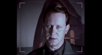 Movie still from “Insomnia” (1997), directed by Erik Skjoldbjærg – A person wearing a suit and tie; Close Up shot, Low angle
