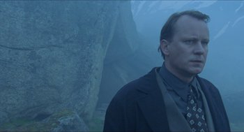 Movie still from “Insomnia” (1997), directed by Erik Skjoldbjærg – A man standing in the middle of a cliff looking into the distance; Close Up shot, Low angle