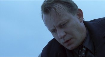 Movie still from “Insomnia” (1997), directed by Erik Skjoldbjærg – A person wearing a suit and tie; Close Up shot, Low angle