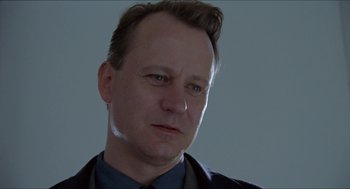 Movie still from “Insomnia” (1997), directed by Erik Skjoldbjærg – A person wearing a suit and tie; Close Up shot, Low angle