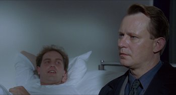 Movie still from “Insomnia” (1997), directed by Erik Skjoldbjærg – A man in a suit and tie next to another man in a suit and tie; Close Up shot, Low angle