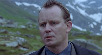 Movie still from “Insomnia” (1997), directed by Erik Skjoldbjærg – A person wearing a suit and tie; Close Up shot, Low angle