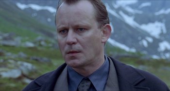 Movie still from “Insomnia” (1997), directed by Erik Skjoldbjærg – A person wearing a suit and tie; Close Up shot, Low angle