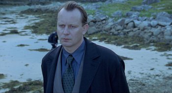 Movie still from “Insomnia” (1997), directed by Erik Skjoldbjærg – A man wearing a suit and tie standing in the snow; Close Up shot, Low angle