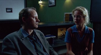 Movie still from “Insomnia” (1997), directed by Erik Skjoldbjærg – A man and a woman sitting in front of each other in a room; Medium shot, Over the shoulder angle