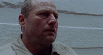 Movie still from “Insomnia” (1997), directed by Erik Skjoldbjærg – A man's face in front of a brick wall; Close Up shot, Low angle
