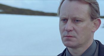 Movie still from “Insomnia” (1997), directed by Erik Skjoldbjærg – A person wearing a black shirt; Close Up shot, Low angle