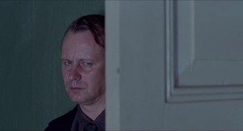 Movie still from “Insomnia” (1997), directed by Erik Skjoldbjærg – A person wearing a suit and tie; Close Up shot, Over the shoulder angle