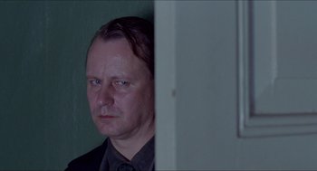 Movie still from “Insomnia” (1997), directed by Erik Skjoldbjærg – A person wearing a suit and tie; Close Up shot, Over the shoulder angle