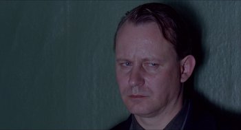 Movie still from “Insomnia” (1997), directed by Erik Skjoldbjærg – A person wearing a black shirt; Close Up shot, Low angle