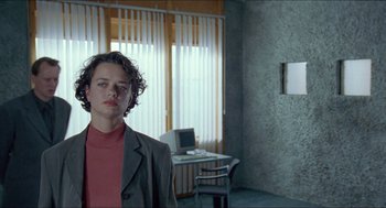 Movie still from “Insomnia” (1997), directed by Erik Skjoldbjærg – A man standing in front of a computer in a room; Medium shot, Low angle