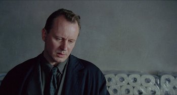 Movie still from “Insomnia” (1997), directed by Erik Skjoldbjærg – A man in a suit and tie looking down; Close Up shot, Low angle