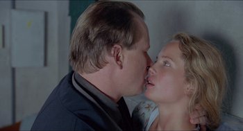 Movie still from “Insomnia” (1997), directed by Erik Skjoldbjærg – A man and a woman kissing each other in front of a window; Close Up shot, Low angle