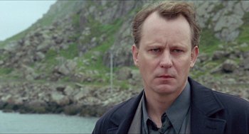 Movie still from “Insomnia” (1997), directed by Erik Skjoldbjærg – A person wearing a suit and tie; Close Up shot, Low angle