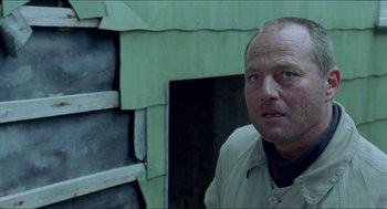 Movie still from “Insomnia” (1997), directed by Erik Skjoldbjærg – A person standing in front of a building; Close Up shot, Low angle