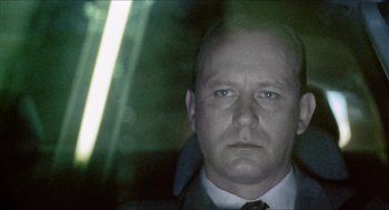 Movie still from “Insomnia” (1997), directed by Erik Skjoldbjærg – A person wearing a suit and tie; Close Up shot, Low angle