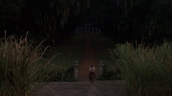 Movie still from “Interview with the Vampire: The Vampire Chronicles” (1994), directed by Neil Jordan – A person riding a horse at night in front of a building; Extreme Wide shot, Over the shoulder angle