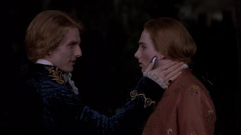 Movie still from “Interview with the Vampire: The Vampire Chronicles” (1994), directed by Neil Jordan – Two men in medieval garb one holding a cell phone to his ear; Close Up shot, Over the shoulder angle