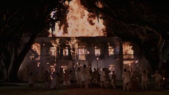 Movie still from “Interview with the Vampire: The Vampire Chronicles” (1994), directed by Neil Jordan – A group of people are standing in front of a burning building; Extreme Wide shot, Low angle