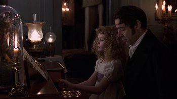 Movie still from “Interview with the Vampire: The Vampire Chronicles” (1994), directed by Neil Jordan – A man and a little girl are playing a piano; Medium shot, Over the shoulder angle