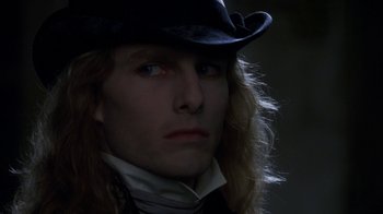 Movie still from “Interview with the Vampire: The Vampire Chronicles” (1994), directed by Neil Jordan – A person with long hair wearing a hat; Close Up shot, Over the shoulder angle
