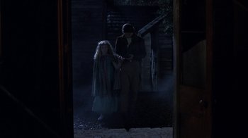 Movie still from “Interview with the Vampire: The Vampire Chronicles” (1994), directed by Neil Jordan – A man and a woman standing next to each other in the dark; Wide shot, Over the shoulder angle