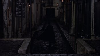 Movie still from “Interview with the Vampire: The Vampire Chronicles” (1994), directed by Neil Jordan – A person walking down a dark street at night; Extreme Wide shot, High angle
