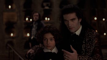 Movie still from “Interview with the Vampire: The Vampire Chronicles” (1994), directed by Neil Jordan – A man and a boy in a room with candles in the background; Medium shot, Over the shoulder angle