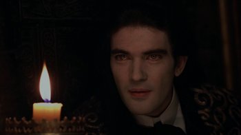 Movie still from “Interview with the Vampire: The Vampire Chronicles” (1994), directed by Neil Jordan – A person with a candle in a dark room; Close Up shot, Over the shoulder angle