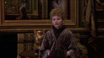 Movie still from “Interview with the Vampire: The Vampire Chronicles” (1994), directed by Neil Jordan – A child dressed as a woman in an old fashion outfit; Medium shot, Over the shoulder angle