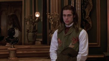 Movie still from “Interview with the Vampire: The Vampire Chronicles” (1994), directed by Neil Jordan – A young man in a vest and tie standing in front of a mirror; Medium shot, Over the shoulder angle