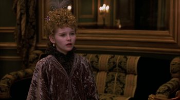 Movie still from “Interview with the Vampire: The Vampire Chronicles” (1994), directed by Neil Jordan – A young girl in a velvet dress with a feather in her hair; Close Up shot, High angle