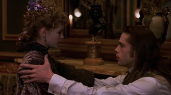 Movie still from “Interview with the Vampire: The Vampire Chronicles” (1994), directed by Neil Jordan – A man and a woman are holding each other in front of a statue; Medium shot, Over the shoulder angle
