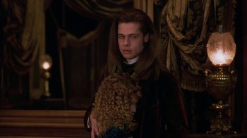 Movie still from “Interview with the Vampire: The Vampire Chronicles” (1994), directed by Neil Jordan – A man with long hair holding a teddy bear; Medium shot, Over the shoulder angle