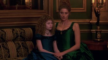 Movie still from “Interview with the Vampire: The Vampire Chronicles” (1994), directed by Neil Jordan – A woman sitting next to a little girl in a green dress; Medium shot, High angle
