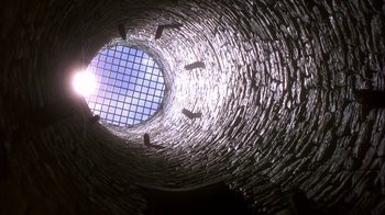 Movie still from “Interview with the Vampire: The Vampire Chronicles” (1994), directed by Neil Jordan – Looking up at a brick tunnel with a sky background; Extreme Wide shot, Low angle