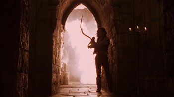 Movie still from “Interview with the Vampire: The Vampire Chronicles” (1994), directed by Neil Jordan – A man holding a sword in a tunnel; Wide shot, Low angle