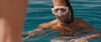 Movie still from “Into the Blue” (2005), directed by John Stockwell – A man in a swimming pool wearing goggles; Close Up shot, High angle