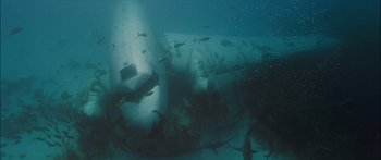 Movie still from “Into the Blue” (2005), directed by John Stockwell – An underwater view of a plane wreck with fish swimming around it; Extreme Wide shot, High angle