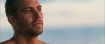 Movie still from “Into the Blue” (2005), directed by John Stockwell – A man's face with the ocean in the background; Close Up shot, Over the shoulder angle